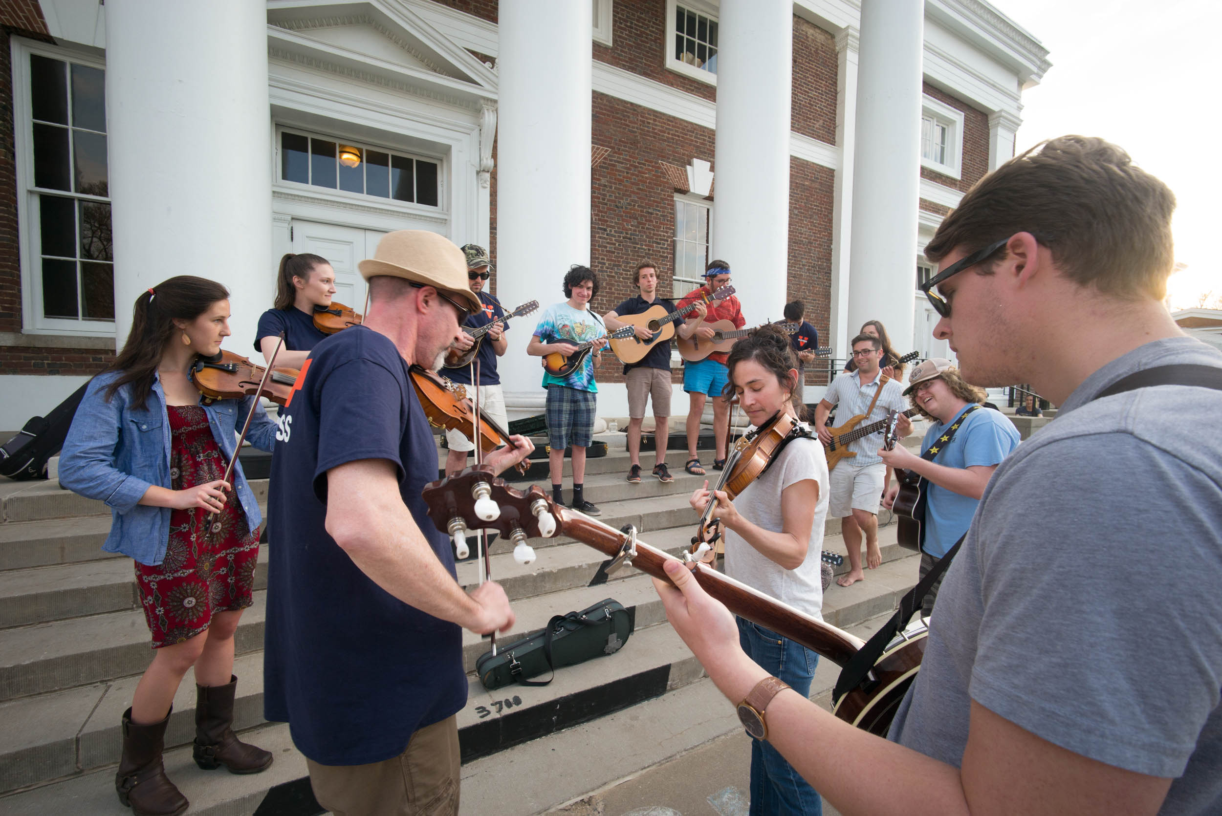 Members of UVA Bluegrass ensemble playing instruments on the steps in front of Old Cabell Hall