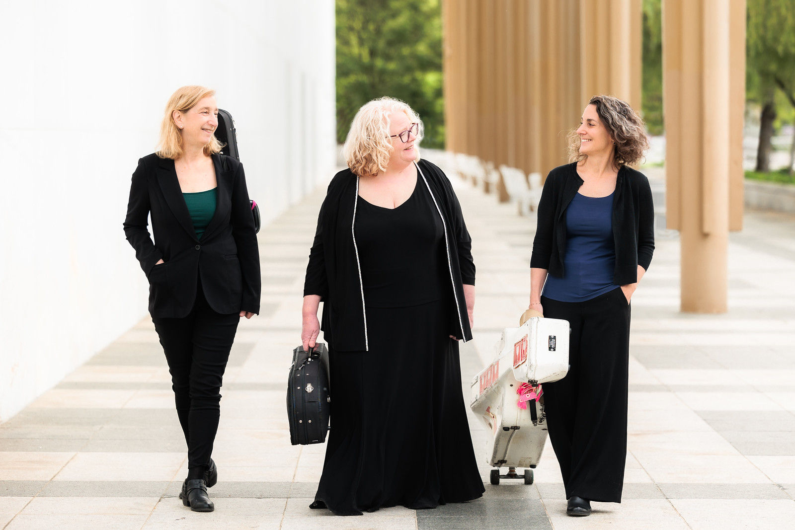 Photo of the Vivaldi Project, three women with instrument cases walking outside.