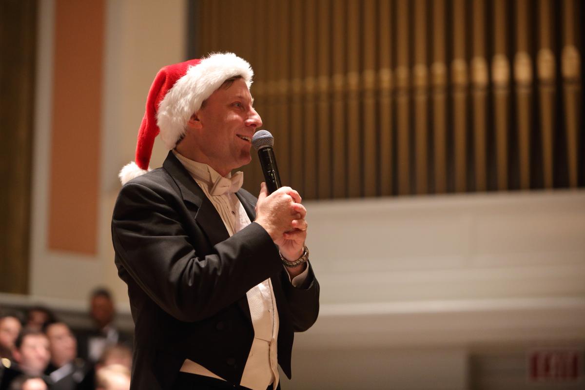 Conductor Michael Slon speaking in Santa hat