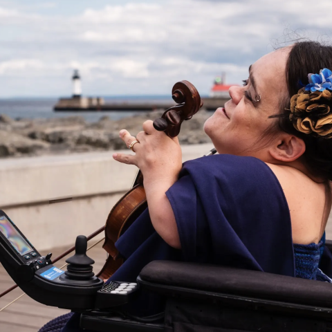 A photograph of musician Gaelynn Lea and her violin