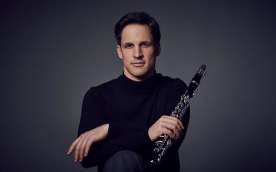 Andreas Ottensamer, holding clarinet, with monochrome background